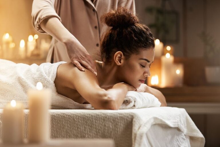 Tender african girl smiling enjoying massage with closed eyes in spa resort